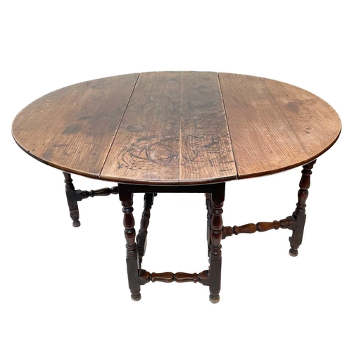 226 - An oak gateleg table. 17th/early 18th century, with an oval drop flap top and turned bobbin and squa... 