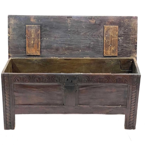 229 - An oak six plank coffer. 18th century, with a carved frieze, on stile feet, height 49cm, width 107cm... 