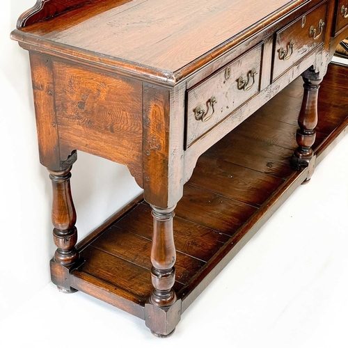 230 - A George III style oak low dresser. 20th century, with a ledge back above four drawers on baluster t... 