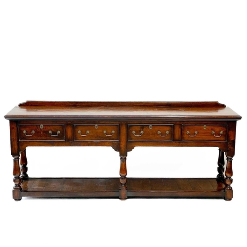 230 - A George III style oak low dresser. 20th century, with a ledge back above four drawers on baluster t... 