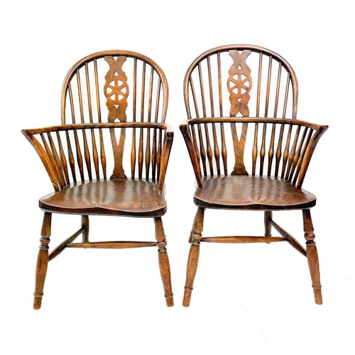 235 - A pair of 19th century ash, elm and beech Windsor chairs. The pierced back splats with cartwheel mot... 