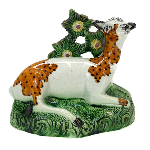 243 - A Staffordshire pearlware figure of a deer. Early 19th century, with a bocage back, on a mound base,... 