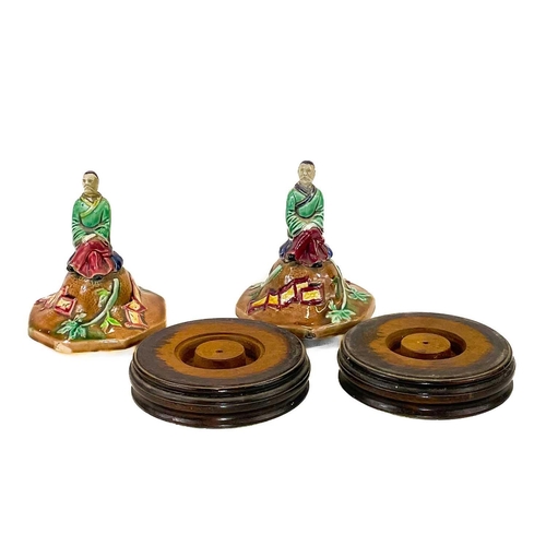 248 - A pair of Majolica vase covers on stands. Modelled with an oriental figure in a garden landscape, ov... 