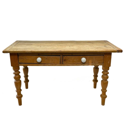 25 - A Victorian pine scullery table. The top with cleated ends, fitted two drawers, on turned legs, heig... 