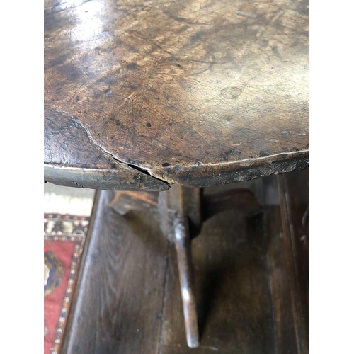 257 - A late Georgian primitive oak circular occasional table. With a figured top, on a chamfered pillar a... 