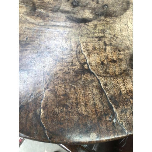 257 - A late Georgian primitive oak circular occasional table. With a figured top, on a chamfered pillar a... 