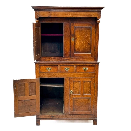 3 - A late George III Welsh oak cupboard Deuddarn The cornice with drop finials above two doors, the pro... 