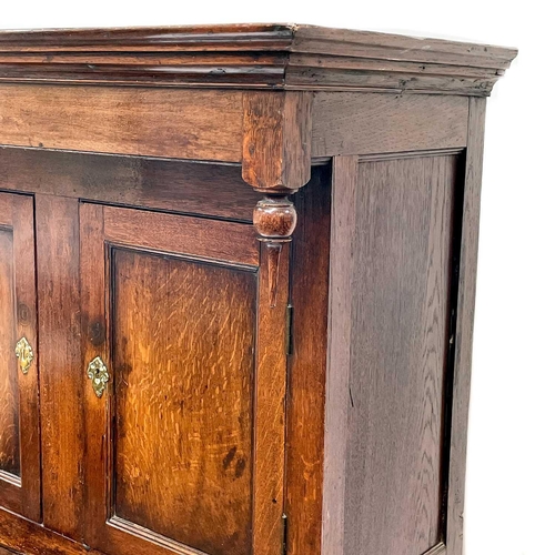 3 - A late George III Welsh oak cupboard Deuddarn The cornice with drop finials above two doors, the pro... 