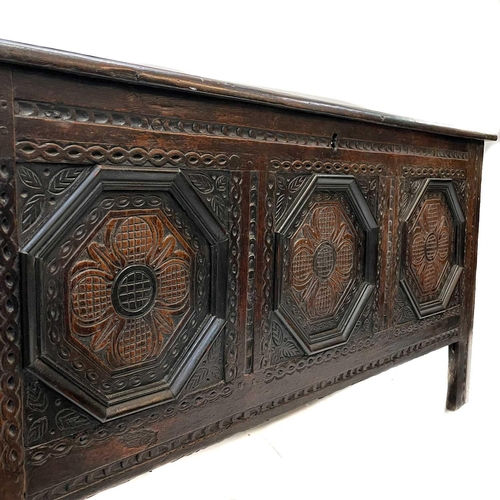 44 - A 17th century oak coffer. With three carved front panels, lift up the rectangular lid on block feet... 