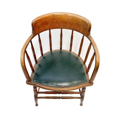 47 - An early 20th century oak bow smokers chair. With leather seat, height 79cm width 57cm depth 50cm.