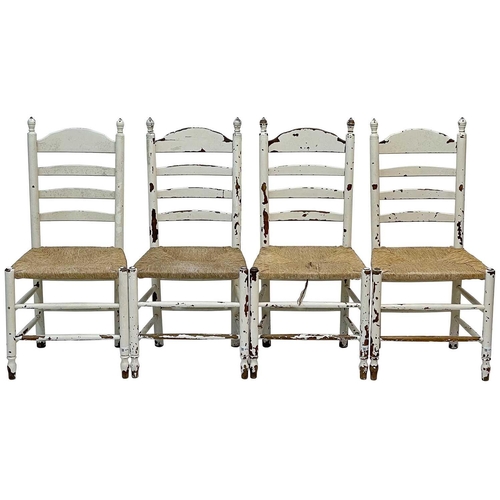 48 - A set of eight white-painted rush seated ladderback dining chairs. Late 19th century, with turned un... 