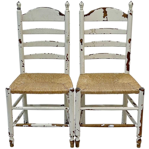 48 - A set of eight white-painted rush seated ladderback dining chairs. Late 19th century, with turned un... 