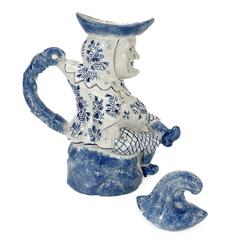 52 - A Deflt blue and white character jug and cover as Mr Punch. Circa 1900, the portly figure modelled s... 