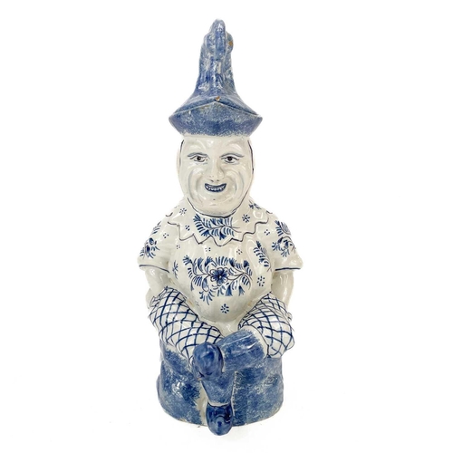 52 - A Deflt blue and white character jug and cover as Mr Punch. Circa 1900, the portly figure modelled s... 