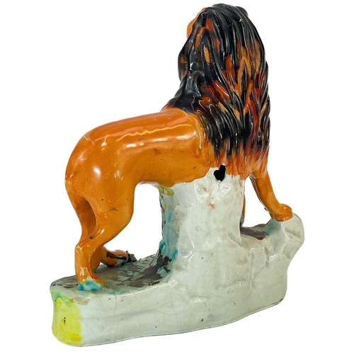 6 - A Victorian Staffordshire figure of a lion. Standing four square on a naturalistic base, height 16.5... 