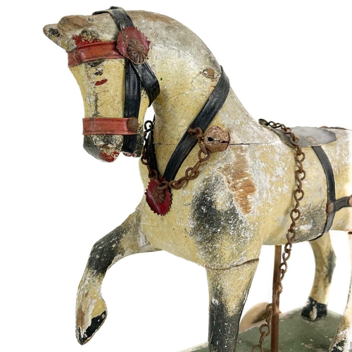 64 - A child's painted toy pull-along horse. Early 20th century, piebald decoration, on a green painted b... 