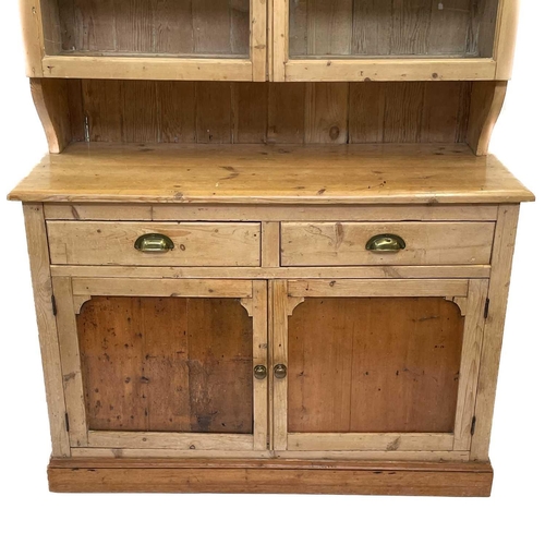 71 - A Victorian pine dresser. The upper part with two glazed doors, the lower part with two drawers and ... 