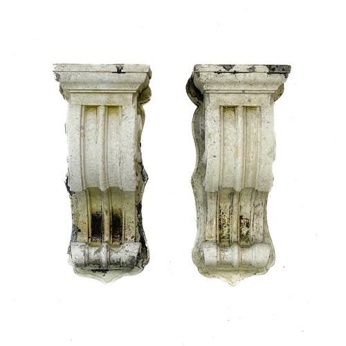 75 - A pair of reconstituted stone corbels. Height 36cm, width 14cm, depth 14.5cm.