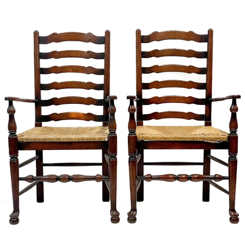 87 - Six 20th century ash and oak ladder back chairs. With drop in rush seats and two carvers. (6)Stirdy,... 