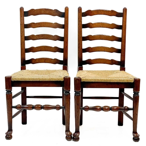 87 - Six 20th century ash and oak ladder back chairs. With drop in rush seats and two carvers. (6)Stirdy,... 