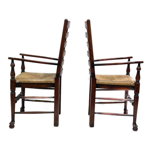 87 - Six 20th century ash and oak ladder back chairs. With drop in rush seats and two carvers. (6)Stirdy,... 