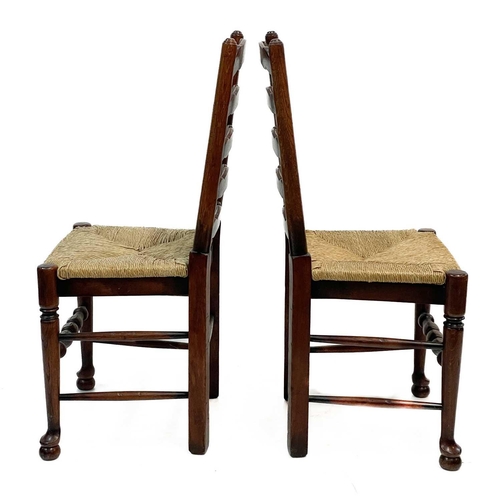 87 - Six 20th century ash and oak ladder back chairs. With drop in rush seats and two carvers. (6)Stirdy,... 