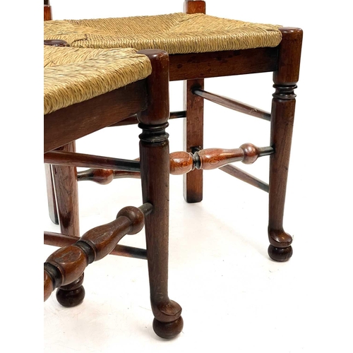 87 - Six 20th century ash and oak ladder back chairs. With drop in rush seats and two carvers. (6)Stirdy,... 