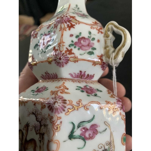131 - A Chinese famille rose porcelain double gourd vase, circa 1760. With twin handles and decorated with... 