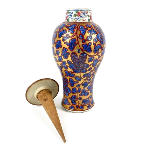 58 - A Chinese 'clobbered' porcelain vase and cover, 19th century. The gilt ground with scrolling foliage... 