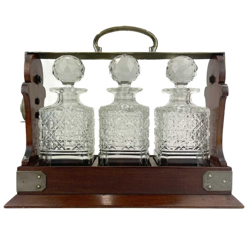 105 - A Betejeman's patent three bottle mahogany tantalus. With silver plated fittings, and stamped marks,... 