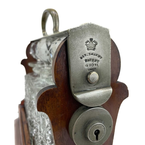 105 - A Betejeman's patent three bottle mahogany tantalus. With silver plated fittings, and stamped marks,... 