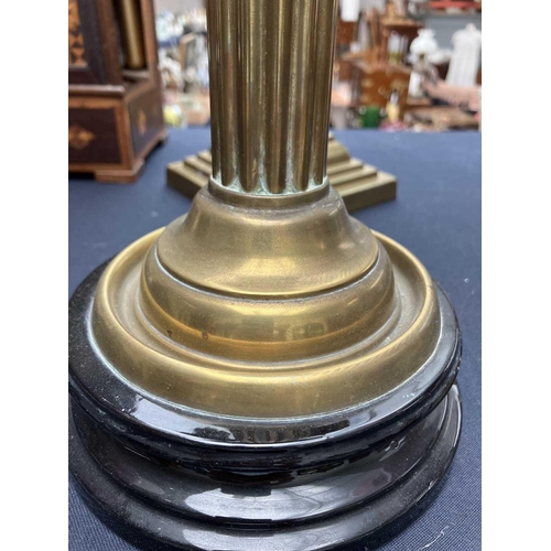 115 - A Victorian brass oil lamp with a glass oil reservoir and cranberry shade. With circular base, mould... 