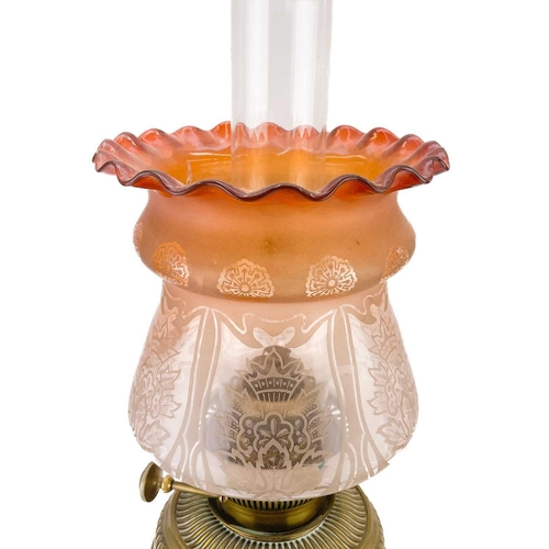 14 - A Victorian brass oil lamp with a brass oil reservoir and an etched orange glass shade. Raised on a ... 