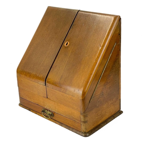 143 - A late Victorian slope front stationary cabinet. With two doors enclosing a fitted interior and a dr... 