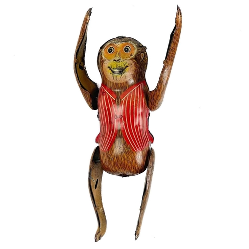 145 - A tin clockwork tumbling monkey circa 1960s. Height 8cm, together with a tin clockwork Police motorc... 