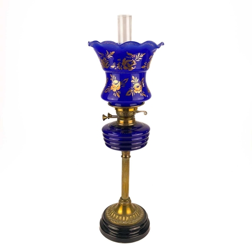 152 - A Victorian brass oil lamp with a blue glass oil reservoir and blue glass shade. Raised on a circula... 