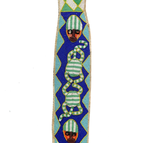 172 - A Yoruba beadwork and cowrie shell sash. Of snake form with multicoulored beads incorporating masks ... 