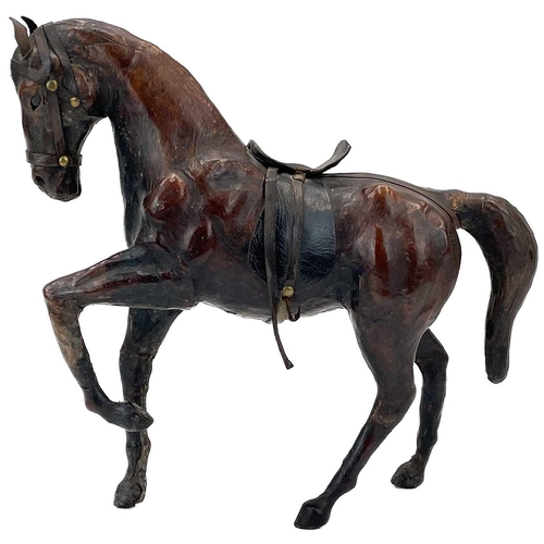 18 - A leather model of a harnessed horse. With inset glass eyes, height 30cm, together with a carved tre... 