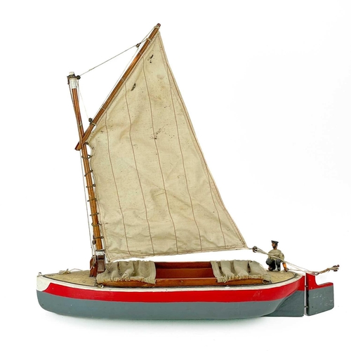 200 - A painted model of a sailing boat. Mounted a painted figure of a fisherman, length 53cm.