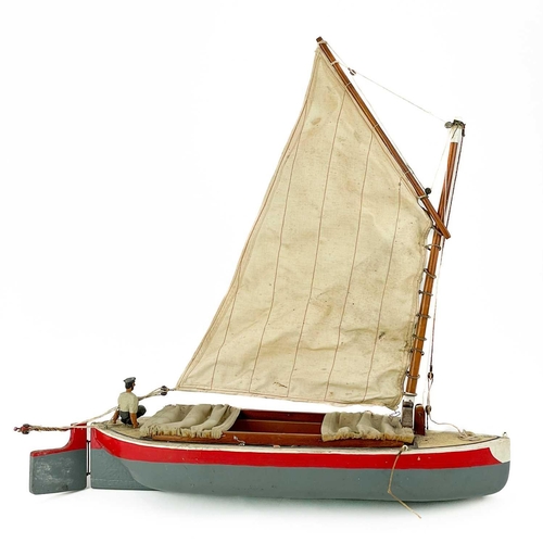 200 - A painted model of a sailing boat. Mounted a painted figure of a fisherman, length 53cm.