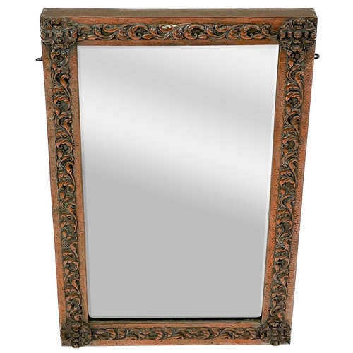 219 - An Art Nouveau copper frame mirror. Decorated in foliate scrolls, 70cm x 42cm.