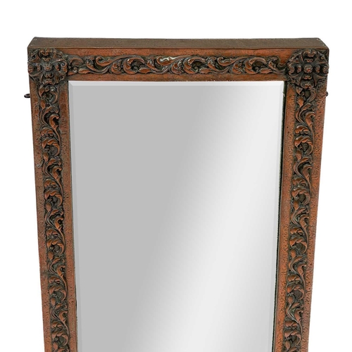 219 - An Art Nouveau copper frame mirror. Decorated in foliate scrolls, 70cm x 42cm.