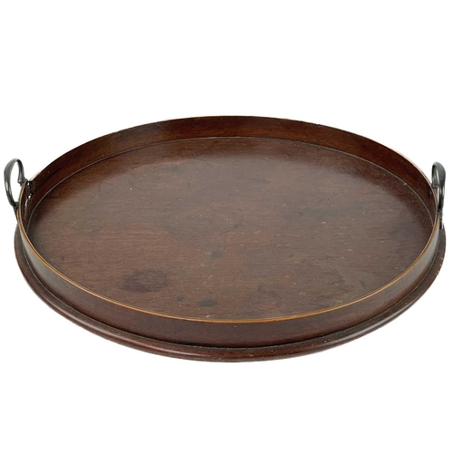 221 - A 19th century circular mahogany tray. With twin brass handles, diameter 47cm, together with two mah... 