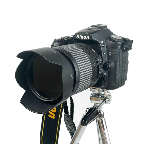 233 - A Nikon D90 camera. Fitted with Nikon AF-S NIKKOR 18-105mm lens, together with an AF Micro NIKKOR 60... 