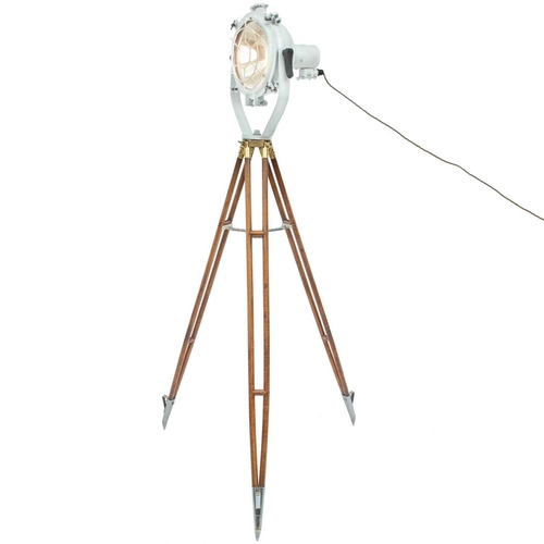 235 - A ship's cargo deck light on a tripod stand. White painted, with a metal grille, the stained beech t... 