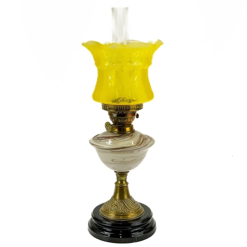 244 - A Victorian brass oil lamp with marble glass reservoir. Yellow glass shade, height 59cm.