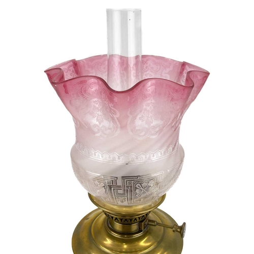 251 - A Victorian brass oil lamp with an etched cranberry glass shade. With brass corinthian style base, b... 