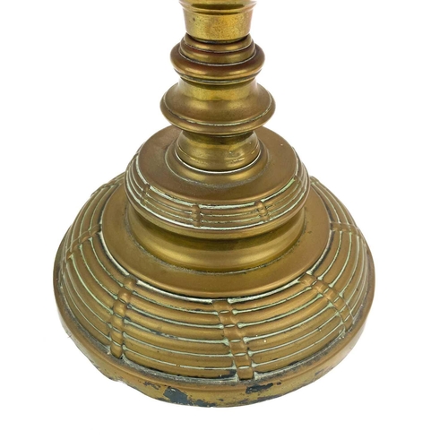 26 - A Victorian brass oil lamp with a cranberry glass shade. Raised on a circular base, with a cranberry... 