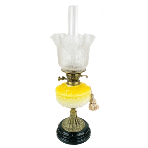 3 - A Victorian brass oil lamp with moulded yellow glass reservoir and etched glass shade. Raised on a c... 