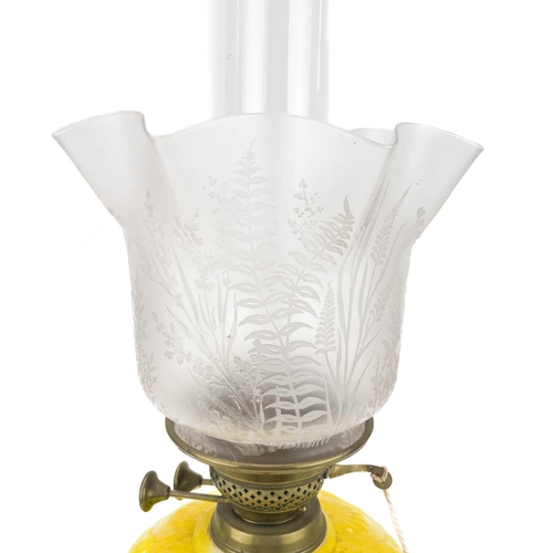 3 - A Victorian brass oil lamp with moulded yellow glass reservoir and etched glass shade. Raised on a c... 